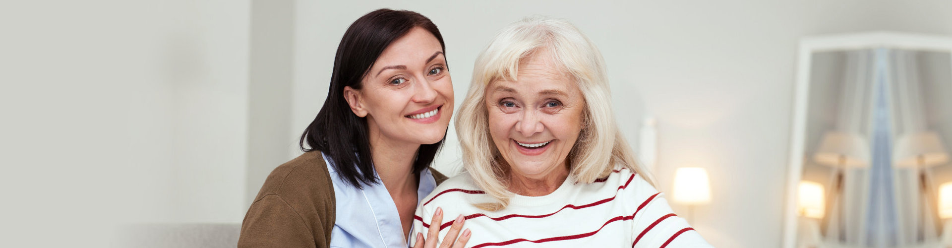 caregiver smiling with elderly woman